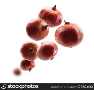 Ripe pomegranates levitate on a white background.. Ripe pomegranates levitate on a white background