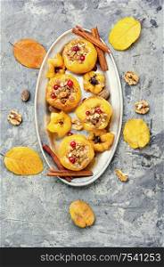 Ripe quince baked with nuts and raisins.Autumn dessert.Stuffed baked quince on a tray. Tasty baked quince