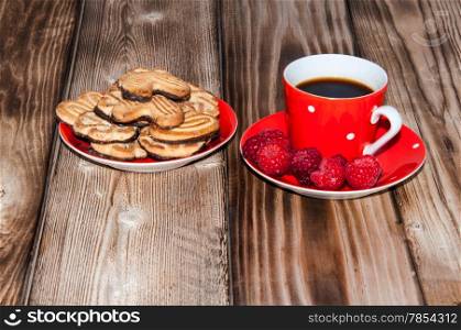 Ripe raspberry and coffee cup on the old wooden table top