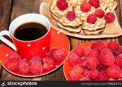 Ripe raspberry and coffee cup on the old wooden table top