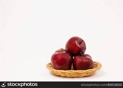 Ripe red apples in wicker basket isolated on white background.