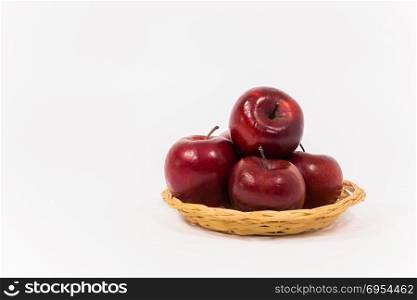 Ripe red apples in wicker basket isolated on white background.