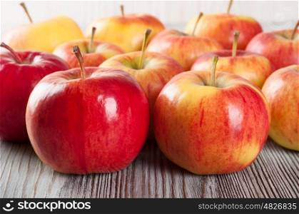 Ripe red apples on a wooden background.
