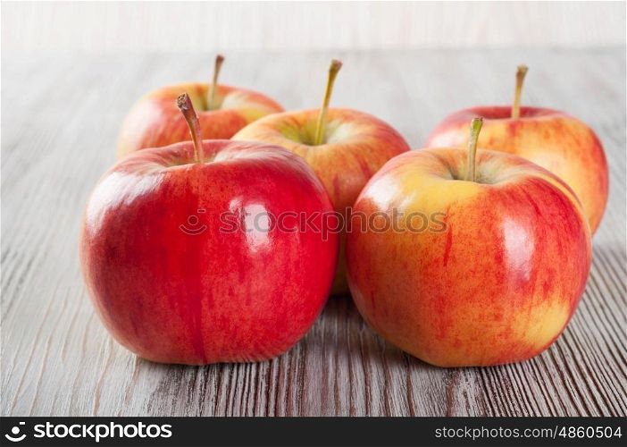 Ripe red apples on a wooden background.