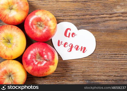 Ripe red apples on a wooden background. Top view. Vegan concept.