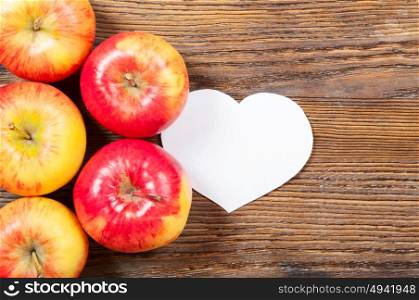Ripe red apples on a wooden background. Top view. Vegan concept.