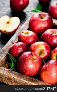 Ripe red apples on a wooden tray. On a black background. High quality photo. Ripe red apples on a wooden tray.