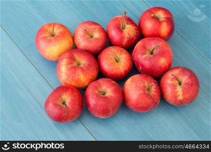 Ripe red apples on blue table close up
