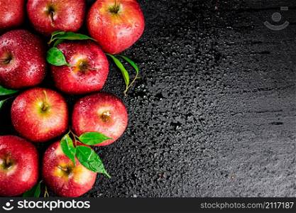Ripe red apples with foliage. On a black background. High quality photo. Ripe red apples with foliage.
