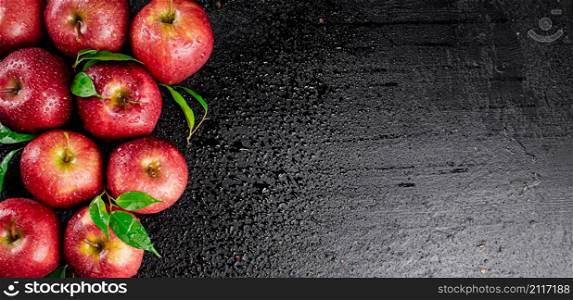 Ripe red apples with foliage. On a black background. High quality photo. Ripe red apples with foliage.
