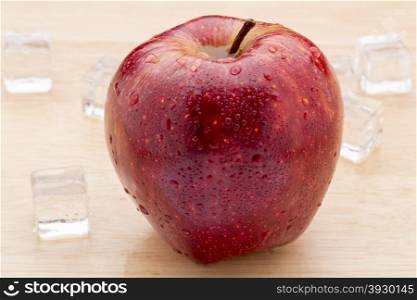 Ripe red apples with water drops on wooden table close up. Ripe red apples with water drops on wooden table