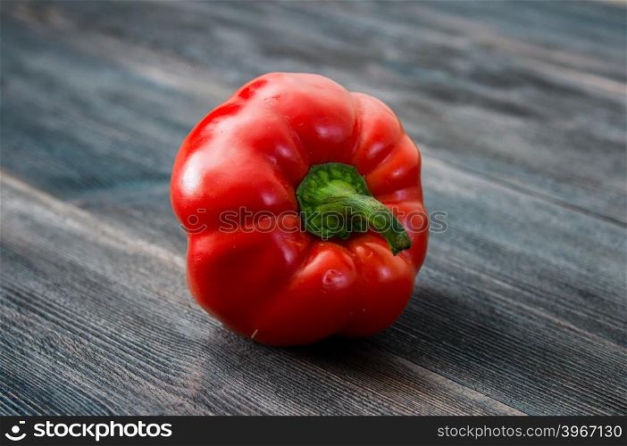ripe red bell pepper on a wooden table