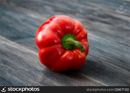 ripe red bell pepper on a wooden table