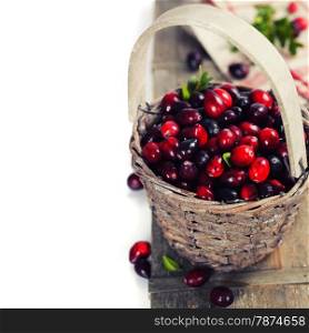 Ripe red cranberries in basket on wooden background