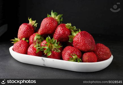 Ripe red strawberries on a black table