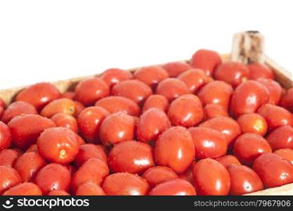 Ripe red tomatoes in wooden box isolated on white