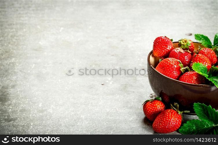 Ripe strawberries in a bowl. On the stone table.. Ripe strawberries in a bowl.