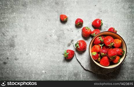 Ripe strawberries in a bowl. On the stone table.. Ripe strawberries in a bowl.