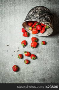 Ripe strawberries in an old pot. On the stone table.. Ripe strawberries in an old pot.