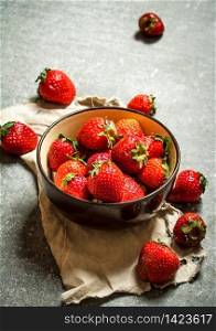 Ripe strawberries in bowl on old fabric. On the stone table.. Ripe strawberries in bowl on old fabric.