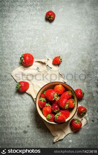 Ripe strawberries in bowl on old fabric. On the stone table.. Ripe strawberries in bowl on old fabric.