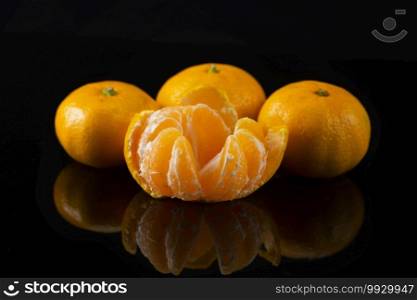 Ripe tangerines on black background with reflection. Tangerines on Black Background with Reflection