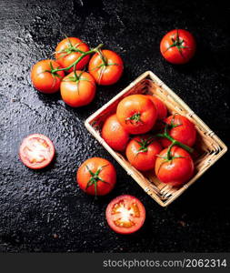 Ripe tomatoes in a basket. On a black background. High quality photo. Ripe tomatoes in a basket.