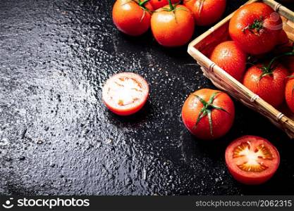 Ripe tomatoes in a basket. On a black background. High quality photo. Ripe tomatoes in a basket.