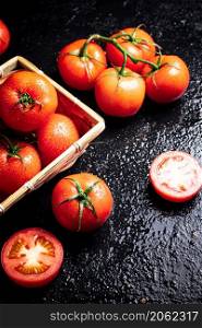 Ripe tomatoes in a basket. On a black background. High quality photo. Ripe tomatoes in a basket.