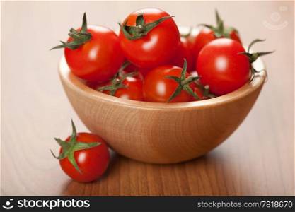 ripe tomatoes in wooden bowl