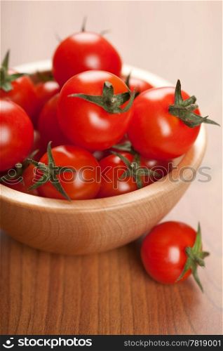 ripe tomatoes in wooden bowl