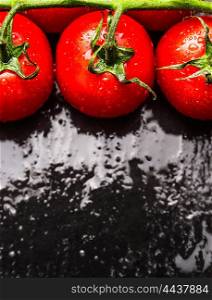 Ripe Tomatoes on black wet background, top view, close up
