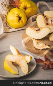 Ripe whole and sliced quinces. Fresh fruit for preparing recipes with cinnamon and lemon. An essential ingredient for a healthy diet