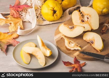 Ripe whole and sliced quinces. Fresh fruit for preparing recipes with cinnamon and lemon. An essential ingredient for a healthy diet