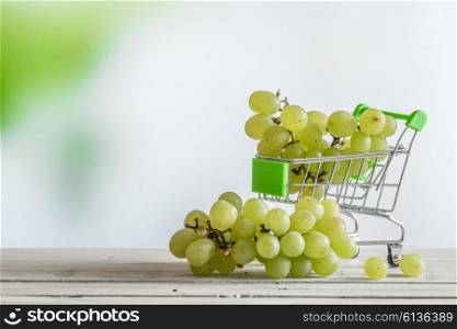 Ripe with green grapes in a shopping cart cart