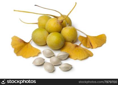 Ripe yellow Ginkgo biloba fruit, nuts and leaves on white background