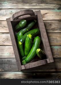 Ripe zucchini in the box. On wooden background. Ripe zucchini in the box.