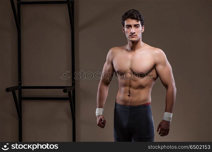 Ripped muscular man in gym doing sports
