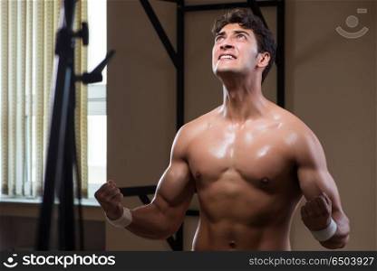 Ripped muscular man in gym doing sports