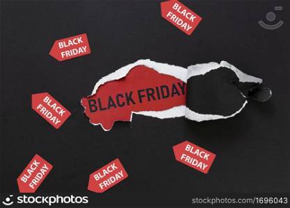 ripped paper revealing black friday text with stickers