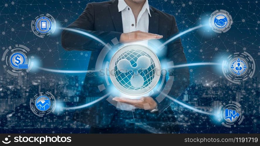Ripple and cryptocurrency investing concept - Businessman holding Ripple (XRP) with mobile application business icons showing exchanging, trading, transfer and investment of blockchain technology.. Ripple XRP and cryptocurrency investing concept.
