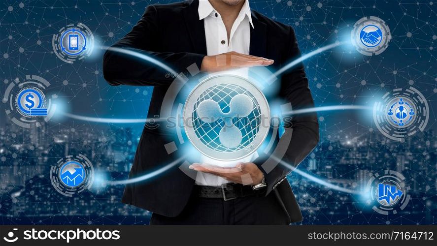 Ripple and cryptocurrency investing concept - Businessman holding Ripple (XRP) with mobile application business icons showing exchanging, trading, transfer and investment of blockchain technology.. Ripple XRP and cryptocurrency investing concept.
