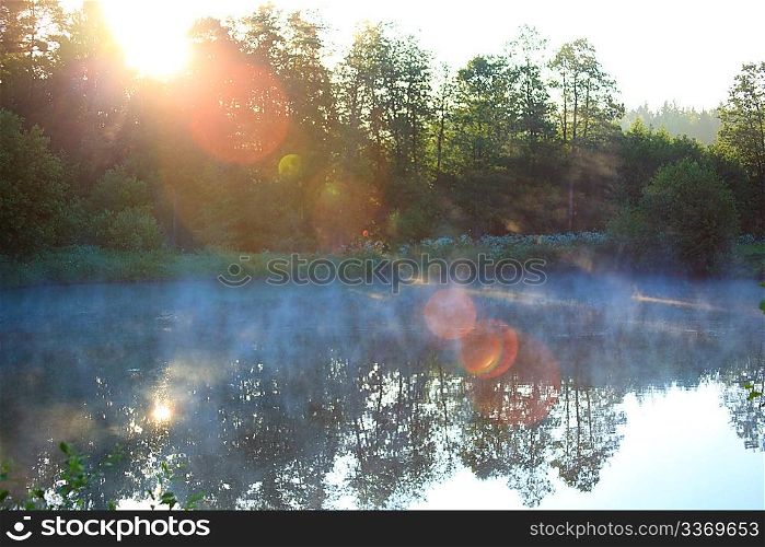 Rising sun beams over lake