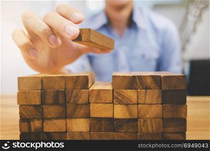 Risk and strategy wealth plan - man hand with wooden block thinking about value investment