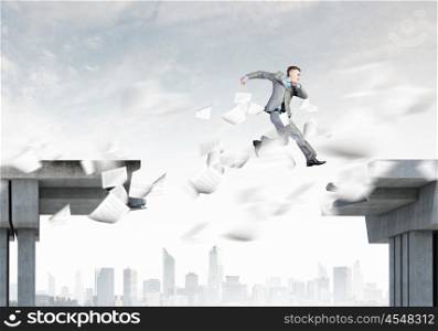 Risk concept. Image of young businessman jumping over gap in bridge