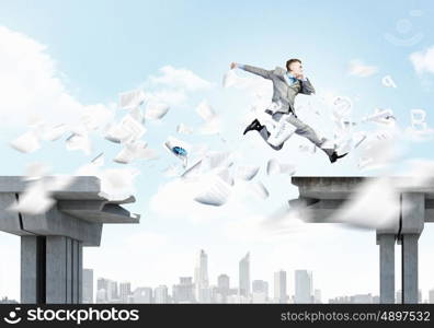 Risk concept. Image of young businessman jumping over gap in bridge