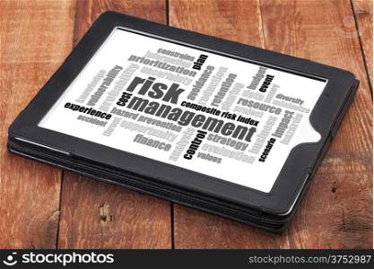 risk management word cloud - a digital tablet on a rustic wooden table