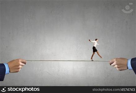 Risky business. Young brave ricky businesswoman balancing on rope