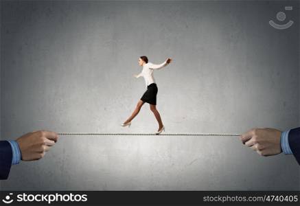 Risky business. Young brave ricky businesswoman balancing on rope