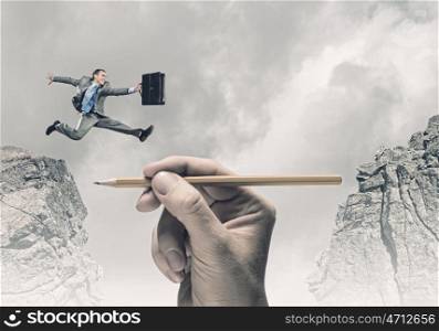 Risky business. Young businessman jumping over gap. Risk concept